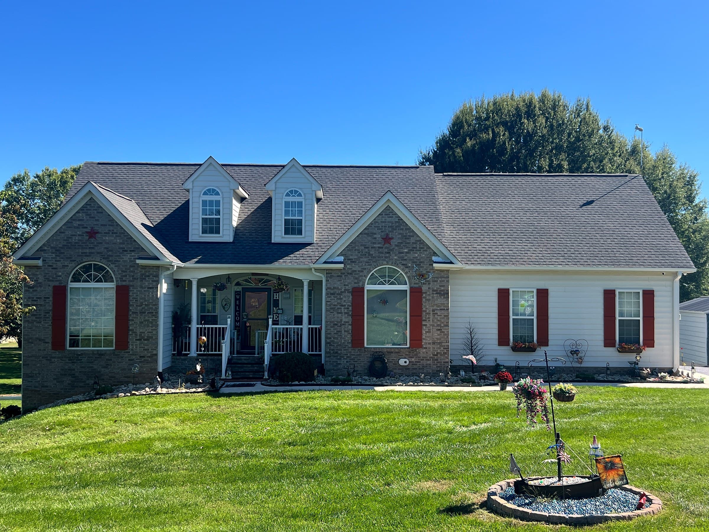 Cape Cod-style home in Culpeper, VA with brick and white siding, two dormers, red shutters, a covered front porch, and a GAF Timberline HDZ Williamsburg Slate roof