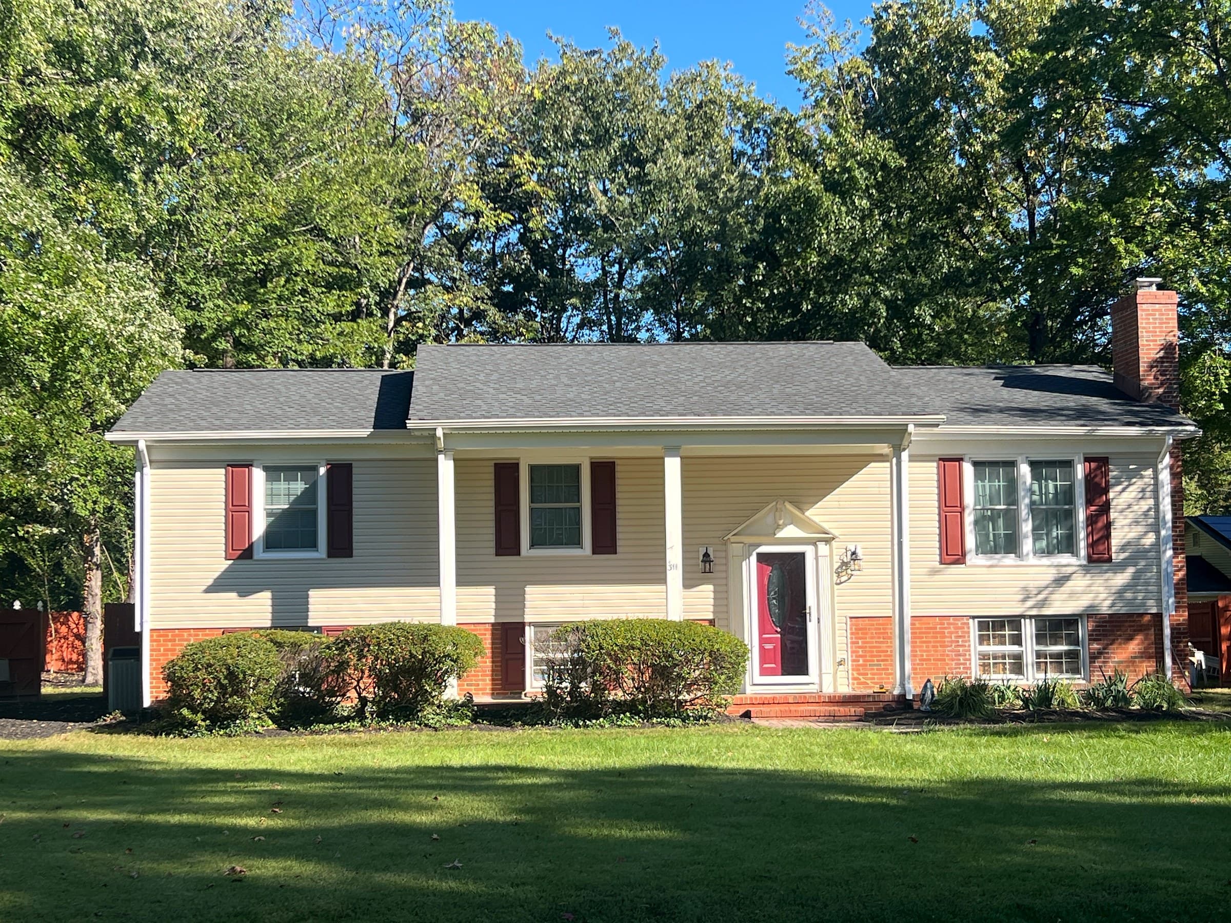 Split-foyer home in the Fredericksburg mailing area of Stafford County, with cream siding, burgundy shutters, a brick chimney, and a new GAF Timberline HDZ Charcoal roof.