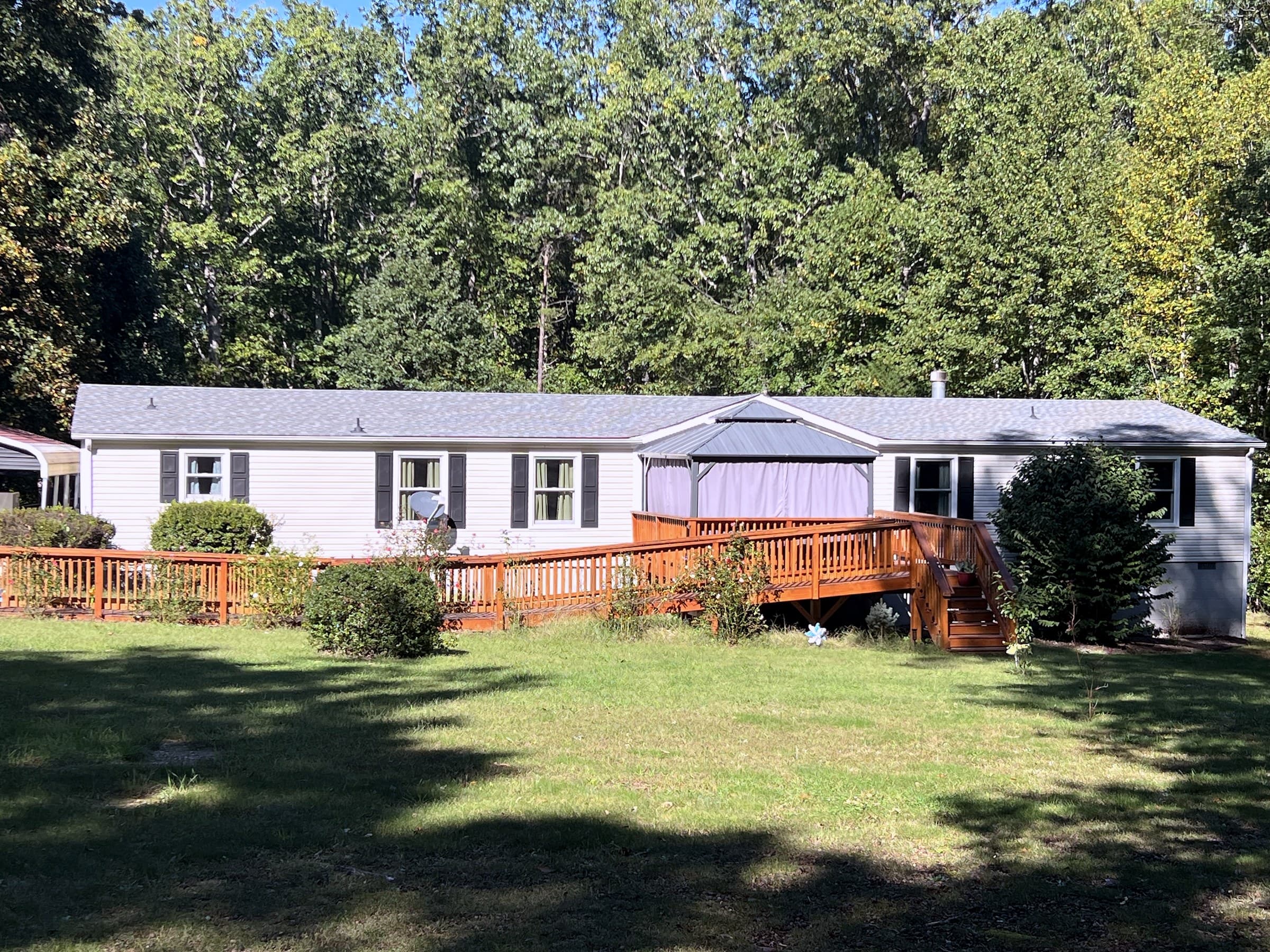 Ranch home in Rhoadesville, VA with a new GAF Timberline HDZ Pewter Gray roof, a wooden deck, and a wooden access ramp