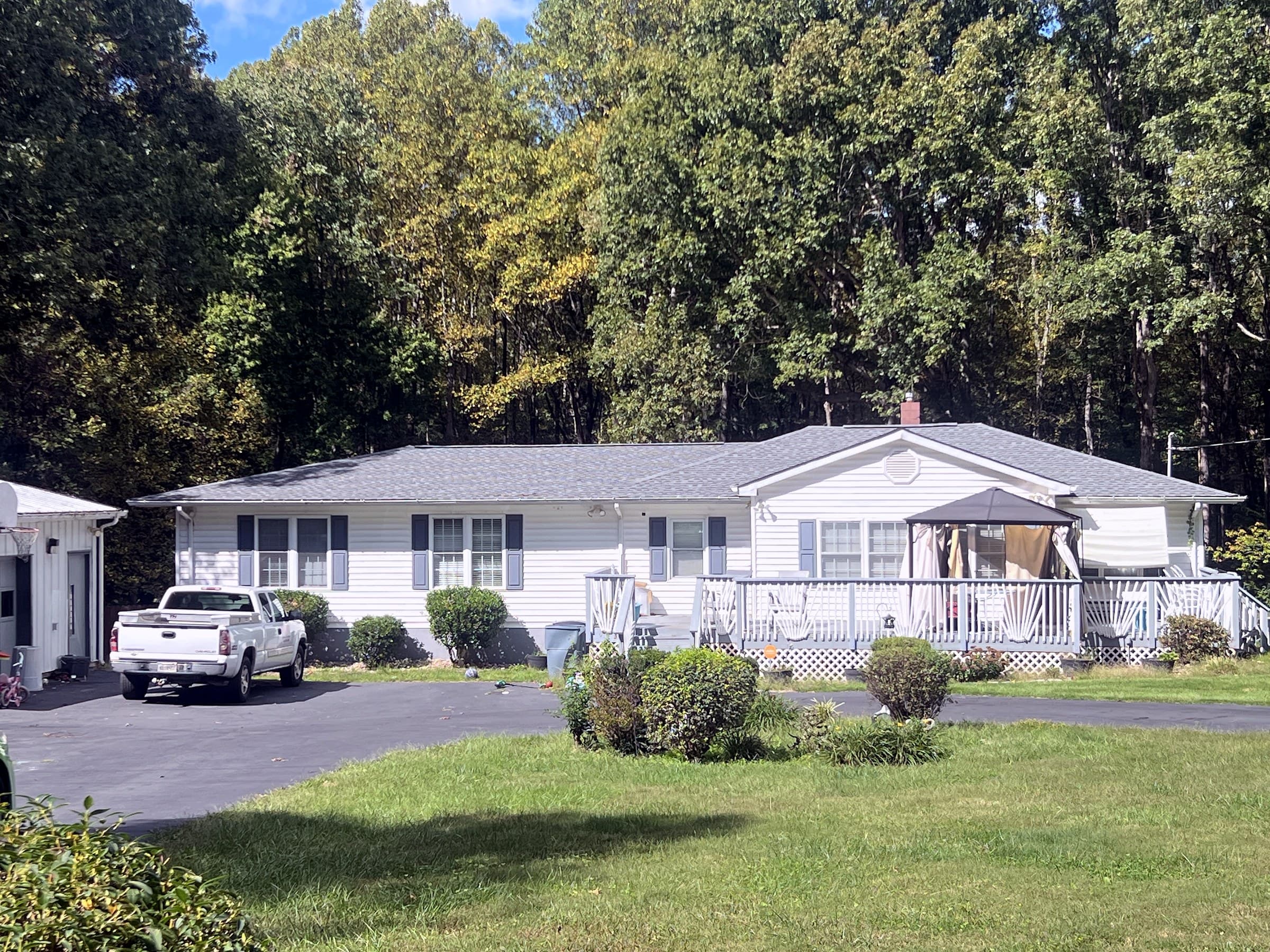 Ranch home in Rhoadesville, VA with a new GAF Timberline HDZ Pewter Gray roof, a deck and gazebo, and a white pickup in the driveway