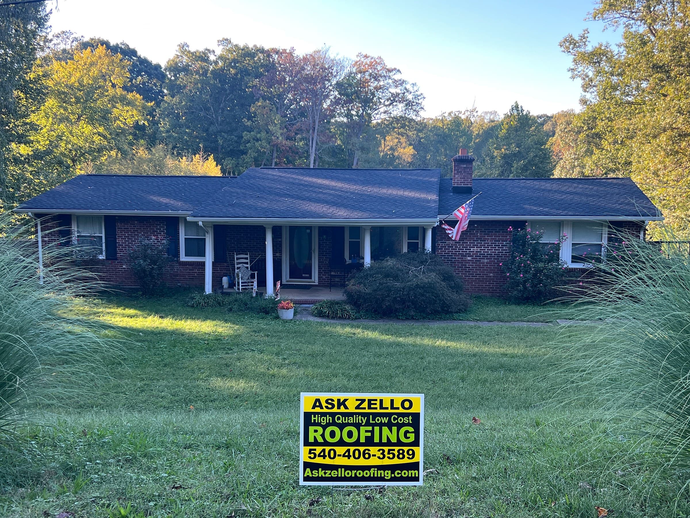 Brick ranch home in Stafford, Stafford County, with black shutters, a covered front porch, a long lawn, and a new GAF Timberline HDZ Charcoal roof.