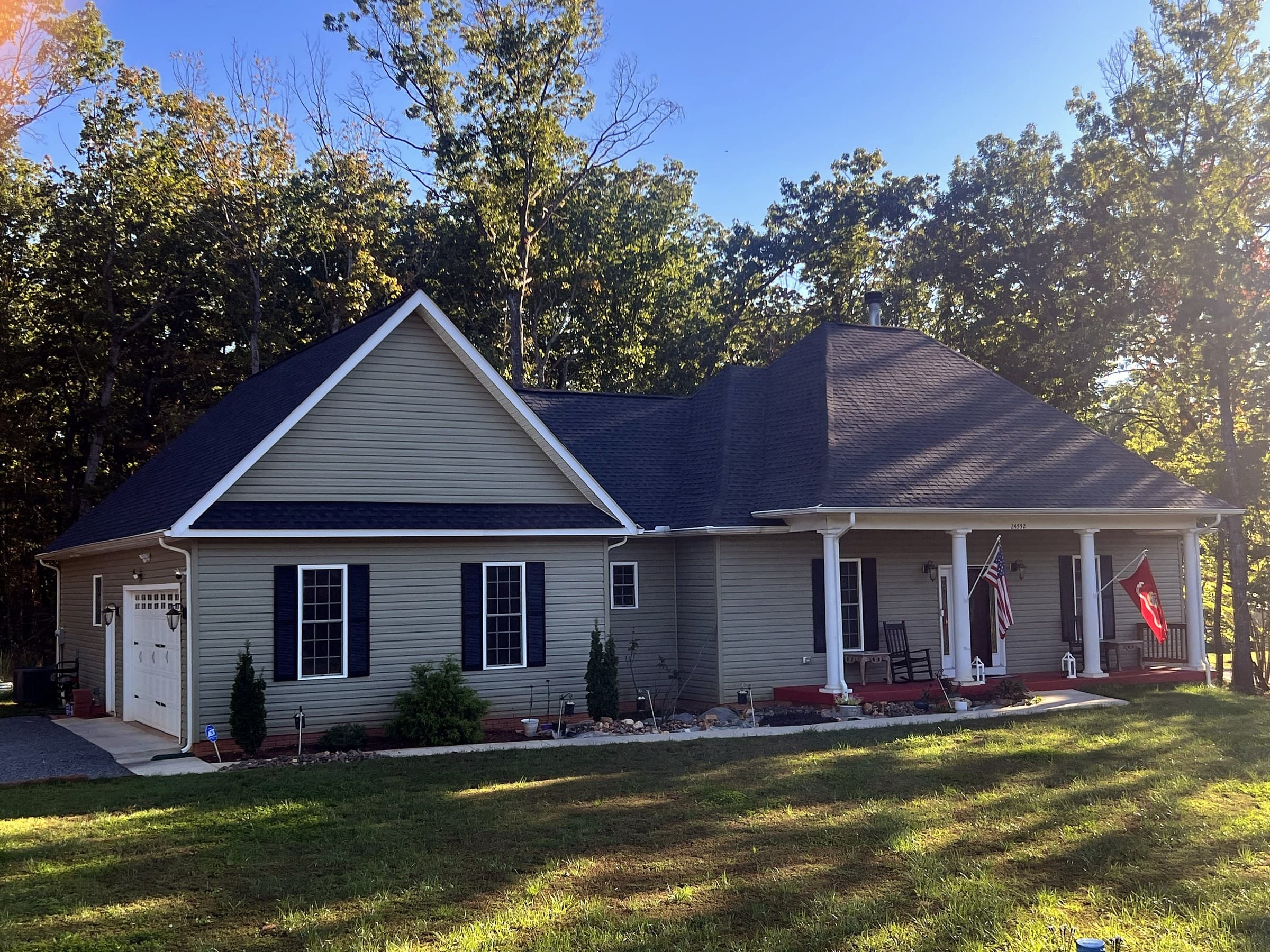 Home in Unionville, VA with sage siding, white trim, flags by the porch, and a new GAF Timberline HDZ Charcoal roof