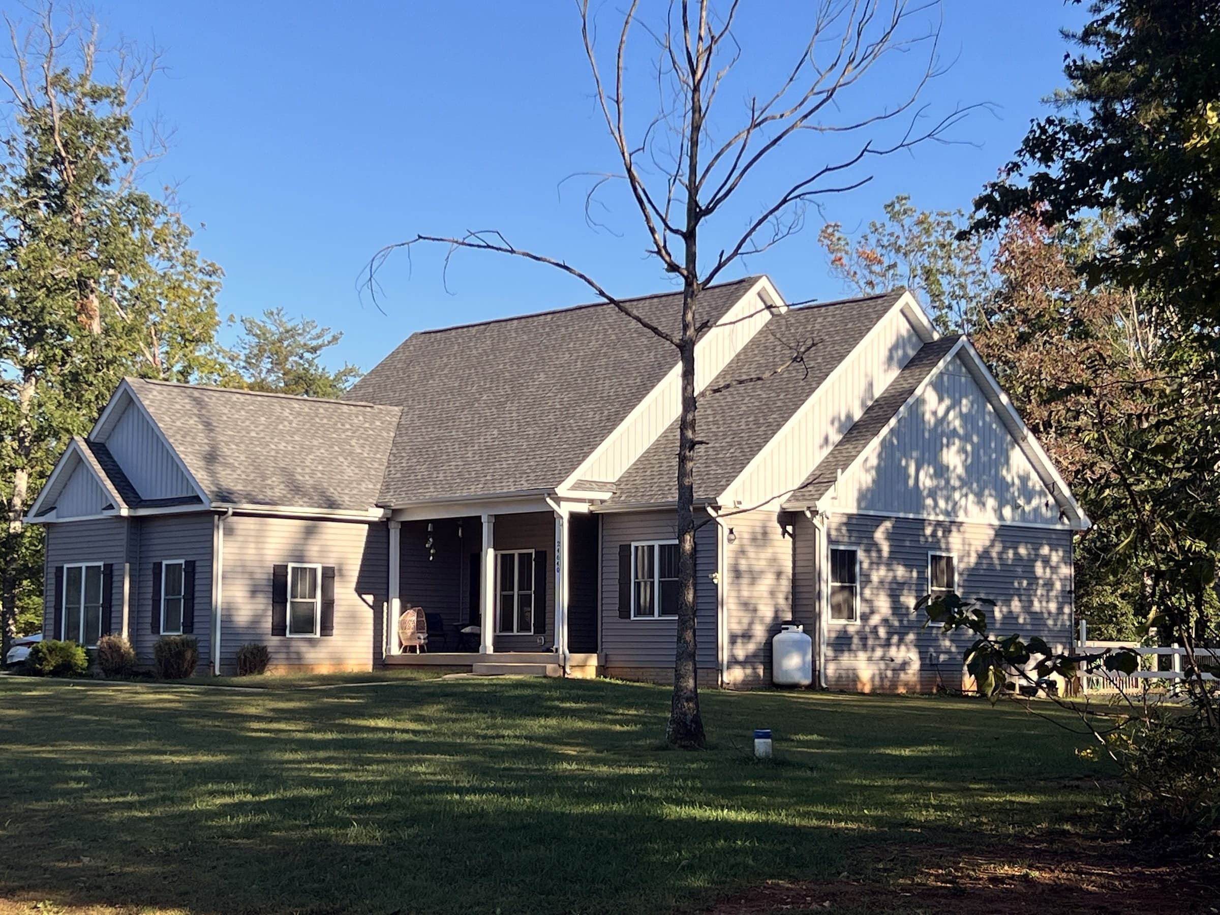 Home in Unionville, VA with a new GAF Timberline HDZ Pewter Gray roof and a thin tree in the foreground